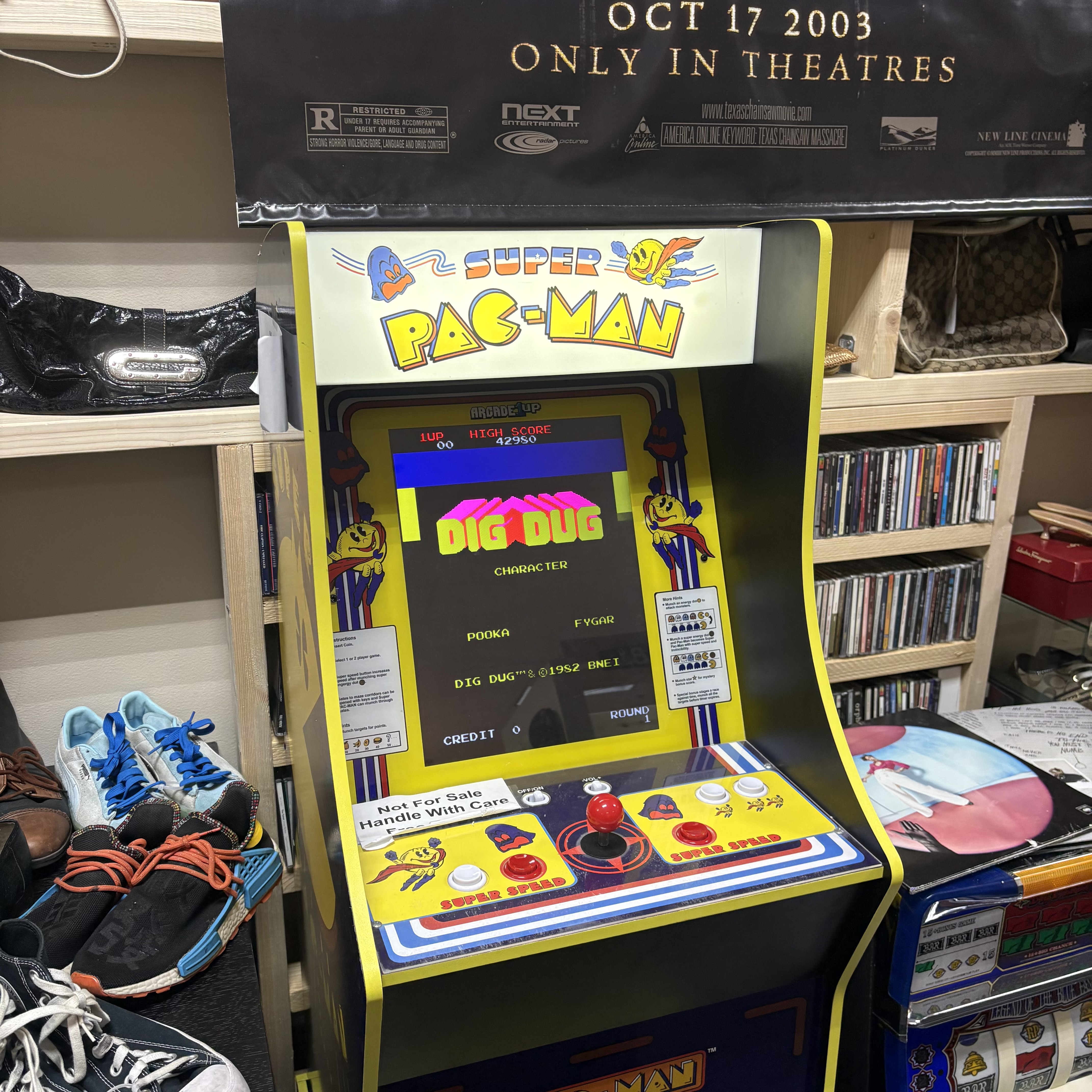 Mini Pac-Man arcade cabinet and nearby media shelves